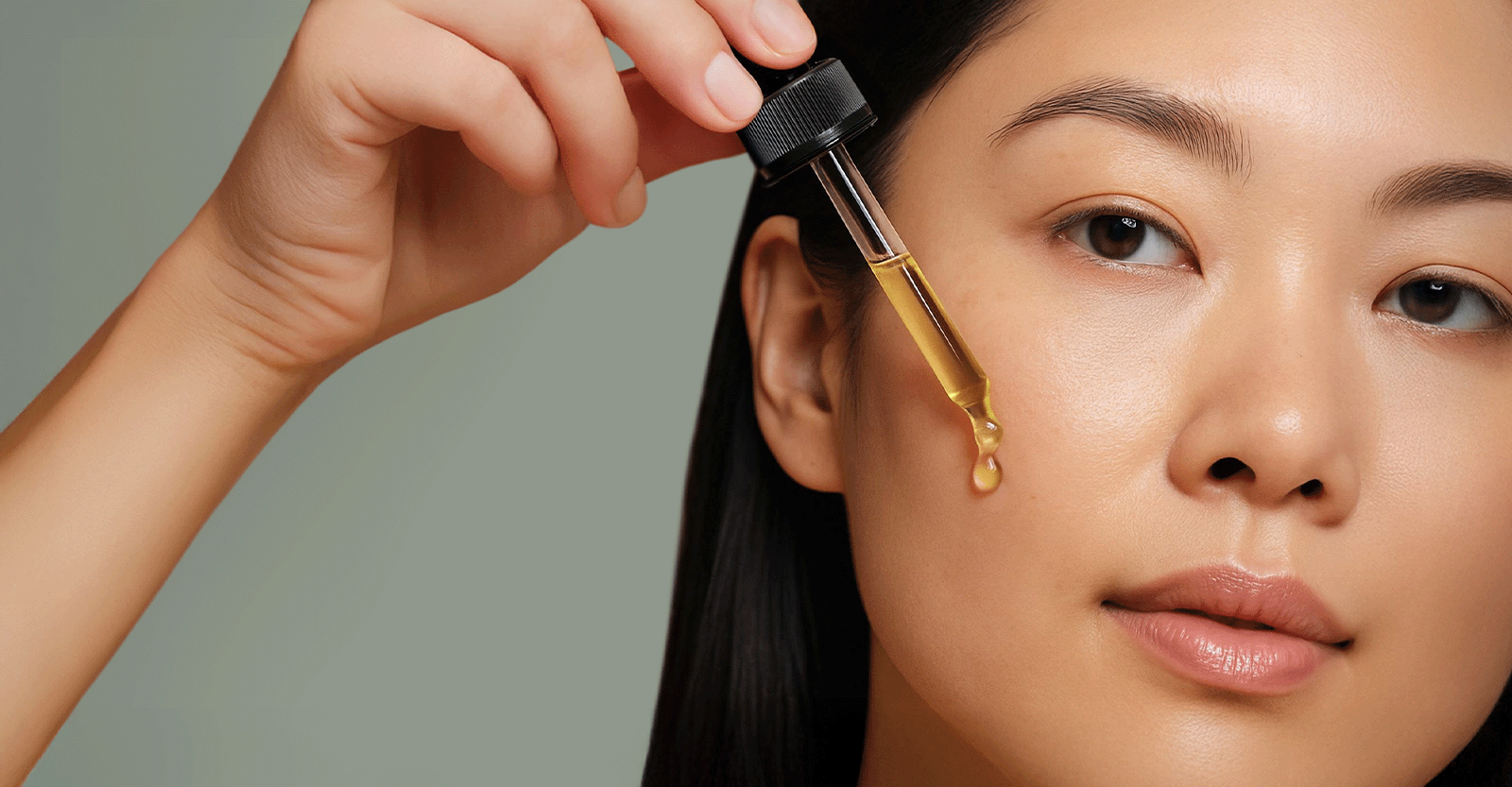 Woman applying Oleo Botanicals Camellia Oil with dropper to cheek for glowing, healthy skin